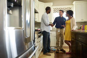 Homeowner and ServiceMaster Restore tech shaking hands in a kitchen